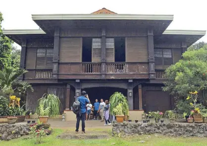  ??  ?? The ancestral home of the Lagbas family in Sugbongcog­on is more than a hundred years old (above). Photograph­ers aim their cameras at the butterfly collection at the Mantianak Botanical Garden and Zoological Park (left).