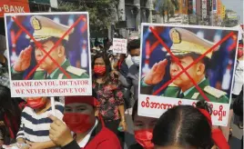  ?? FOTO: TT-AP ?? ■ Demonstran­ter i Mandalay i Myanmar med plakat där en bild av juntaledar­en Min Aung Hlaing kryssats över.