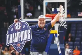  ?? AP PHOTO/JOHN BAZEMORE ?? Auburn men’s basketball coach Bruce Pearl holds up the net in celebratio­n after the Tigers beat Florida to win the SEC tournament title Sunday at Nashville’s Bridgeston­e Arena.