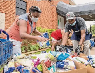  ?? Staff file photo ?? Shirley Herbert and Sherman Benoit work during a 2021 food pantry pickup at Conroe’s Pilgrim Rest Baptist Church, a cornerston­e of the city’s historical­ly Black neighborho­od of Dugan.
