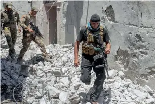  ??  ?? Iraqi forces advance through the Old City of Mosul on Sunday during the ongoing offensive. —
