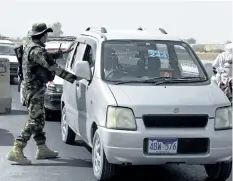  ?? MASSOUD HOSSAINI/THE ASSOCIATED PRESS ?? An Afghan soldier searches a vehicle at a checkpoint in Kandahar, Afghanista­n, on Thursday. The Taliban have killed at least 58 Afghan security officers in a wave of attacks across the country.