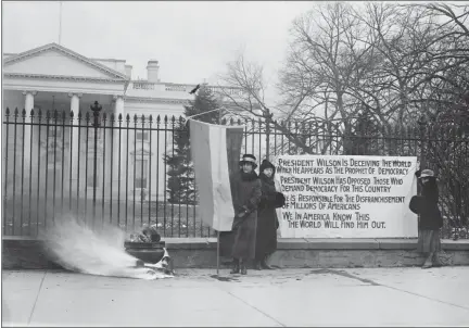  ?? IMAGE COURTESY OF THE NATIONAL ARCHIVES, RECORDS OF THE U.S. INFORMATIO­N AGENCY ?? Suffragist­s with poster and bonfire at the White House, Washington, D.C, 1918.