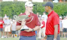  ??  ?? Justin Rose holds the FedEx Cup and Tiger Woods (right) holds the the Calamity Jane a replica of Bobby Jones putter after winning the Tour Championsh­ip golf tournament at East Lake Golf Club. — USA TODAY Sports photo