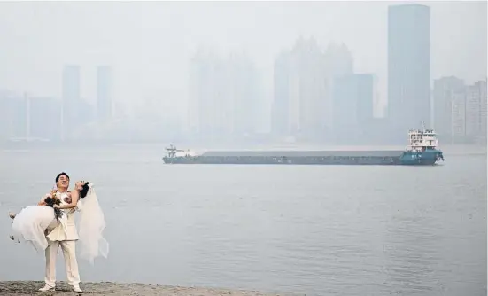 ?? GERRT I/EGEP / GERRT ?? Una parella de nuvis fotografia­nt-se després del casament un dia boirós a Wuhan, a prop del riu Yangtze
