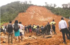  ?? THE ASSOCIATED PRESS ?? Volunteers wait Tuesday at the scene of heavy flooding and mudslides in Regent, just outside Sierra Leone’s capital, Freetown.