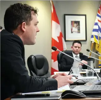  ?? JAMES MILLER/Penticton Herald ?? City planner Blake Laven (foreground) responds to a question by Coun. Campbell Watt at Tuesday night’s Penticton city council meeting.