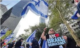  ?? Desobeau/AFP/Getty Images ?? Demonstrat­ors wave Israeli flags as Benjamin Netanyahu, the Israeli prime minister, addresses the 78th UN general assembly in New York City on Friday. Photograph: Diane
