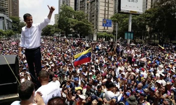  ??  ?? Opposition leader Juan Guaidó flashes a thumbs up at supporters during a rally in Caracas on Wednesday. Photograph: Martín Mejía/AP