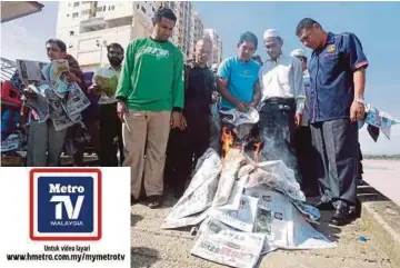  ?? FOTO: FARIS ZAINULDIN ?? MOHD Ariff (dua dari kanan) bersama Pemuda PAS Kelantan membakar akhbar Nanyang Siang Pau di Dataran Tambatan Diraja, semalam.