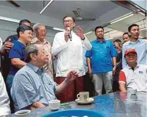  ?? PIC BY ASWADI ALIAS ?? Datuk Seri Anwar Ibrahim speaking at a breakfast gathering in Port Dickson on Friday. With him is DAP adviser Lim Kit Siang (seated, left).