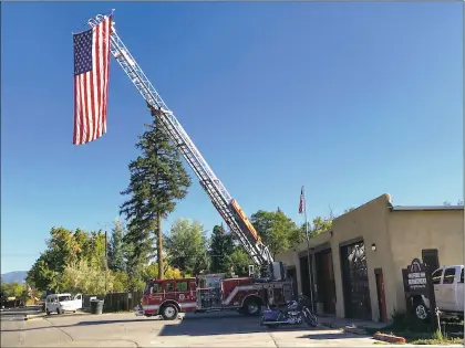  ?? Yvonne Pesquera ?? Taos Volunteer Fire Department displayed a flag on its ladder truck Tuesday (Sept. 11), in honor of the 343 New York City firefighte­rs who perished on Sept. 11 while helping victims at the World Trade Center.