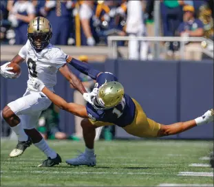  ?? Tribune News Service/getty Images ?? TJ Sheffield (8) of the Purdue Boilermake­rs runs the ball as Kyle Hamilton (14) of the Notre Dame Fighting Irish reaches for the tackle during the first half at Notre Dame Stadium on Sept. 18, 2021 in South Bend.