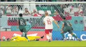  ?? AP ?? Poland keeper Wojciech Szczesny saves a penalty by Saudi Arabia’s Salem Al-dawsari (R).