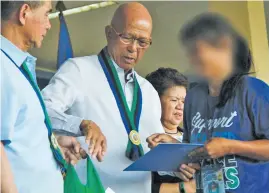  ?? ?? SECRETARY Lorenzana handing over E-CLIP benefits to a former rebel during a Task Force Balik-loob awarding ceremony