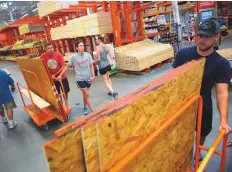  ?? Bloomberg ?? People stock up on plywood, used for barricadin­g windows in a storm, at a Home Depot in Wilmington, North Carolina.