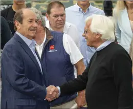  ?? BENOIT PHOTO VIA AP ?? Co-owner Karl Watson, left, congratula­tes trainer Bob Baffert on scoring his record ninth Gold Cup victory after Defunded and jockey Juan Hernandez captured the Grade I $400,000Hollywo­od Gold Cup race on Monday at Santa Anita Park.