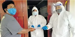  ?? Photo: Ronald Kumar ?? Vashist Muni College staff, Seema Singh and Nazra Hussain (right) in full protective gear as they assist parent, Litia Matanisiga with printed home study material in Navua on July 5, 2021.