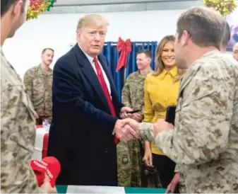  ?? GETTY IMAGES FILES ?? President Donald Trump and first lady Melania Trump greet members of the U.S. military during an unannounce­d trip to Al Asad Air Base in Iraq last December.