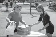  ?? Jeremy Stewart, File ?? In this June 2020 file photo Floyd County Schools student Jaeleigh Wiggins (left) picks up free meals and a box of fresh produce from Rome-Floyd YMCA staff member Allie McDermont at the facility on East Second Avenue.