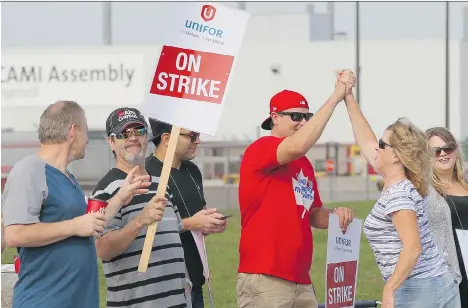  ?? DAVE CHIDLEY/THE CANADIAN PRESS ?? Employees of GM’s CAMI assembly factory stand on the picket line in Ingersoll, Ont., on Monday. Talks with the Unifor Local 88 fell apart Sunday, partly because GM was unable to promise long-term commitment­s to prevent the shift of its production to...