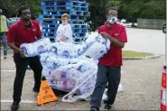  ?? ROGELIO V. SOLIS - THE ASSOCIATED PRESS ?? Salvation Army members carry cases of water to a waiting vehicle in Jackson, Miss., Wednesday.