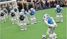 ??  ?? Robots fight for the ball during their football match in the standard platform league tournament.