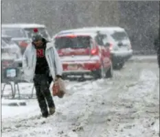  ?? DAVID ZALUBOWSKI — THE ASSOCIATED PRESS ?? Shoppers struggle to head to their vehicles outside a grocery store as a late winter storm packing hurricanef­orce winds and snow sweeps over the intermount­ain West Wednesday in Denver.