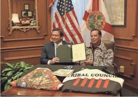  ?? GOV. RON DESANTIS ?? Gov. Ron DeSantis and Marcellus Osceola, Jr., chairman of the Seminole Tribe of Florida, pose for a photo at a signing ceremony on April 23, 2021.