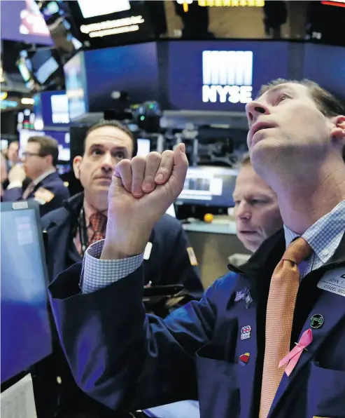  ?? RICHARD DREW / THE ASSOCIATED PRESS ?? Traders on the floor of the New York Stock Exchange on Friday, which was a day of wild swings that saw U. S. stocks post a late-afternoon rally to end on a 330-point gain by the Dow Jones industrial average.