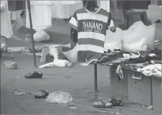  ?? WALLY SANTANA/AP ?? A Thailand souvenir T-shirt at the scene of an explosion littered with blood and small pairs of shoes at a main protest site in Bangkok, Thailand.