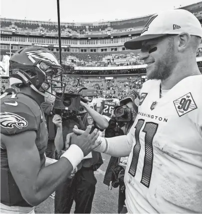  ?? AP ?? Eagles quarterbac­k Jalen Hurts, left, and Commanders quarterbac­k Carson Wentz greet one another after a Sept. 25 game in Landover, Md. The Eagles won 24-8.