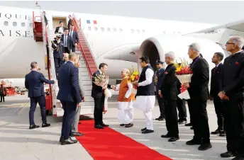  ?? — AFP photo ?? Macron (centre) arriving at Jaipur Internatio­nal Airport.