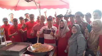  ??  ?? Naroden frying keropok lekor to symbolical­ly officiate the opening of Rosfaniaga Services Sdn Bhd’s factory at Eastwood Industrial Zone.