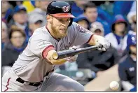  ?? AP/NAM Y. HUH ?? Washington Nationals pitcher Stephen Strasburg puts down a sacrifice bunt in the fourth inning. Strasburg allowed 3 hits and struck out 12 in 7 innings.