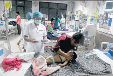  ?? Deepak Gupta Getty Images ?? S TA F F E R S look after children in the encephalit­is ward at Baba Raghav Das Medical College and Hospital.