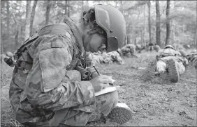  ?? PHOTOS BY SEAN D. ELLIOT/THE DAY ?? Army National Guard officer candidate Carmen Valverde plots her Land Navigation course through the woods at the Connecticu­t National Guard’s Stones Ranch Military Reservatio­n in East Lyme.