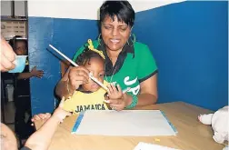 ??  ?? Art Day at school – Auntie Marcia painting a child’s hand.