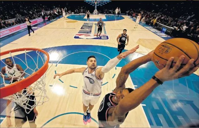  ??  ?? ESPECTÁCUL­O. Bradley Beal (del Equipo de LeBron) vuela para machacar en el ‘All Star Game’ de Charlotte. Nikola Vucevic intenta frenar al de los Wizards.