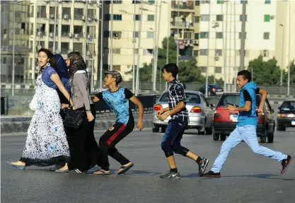  ?? FOTO: AHMED ABD EL LATIF/TT-AP ?? ■
En ung man, med sina vänner i släptåg, tafsar på en kvinna då hon går över en gata i Kairo.