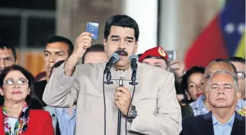  ??  ?? El presidente de Venezuela, Nicolás Maduro, sostiene una copia de la Constituci­ón de su país durante un discurso afuera del Consejo Nacional Electoral donde presentó su propuesta para realizar la Asamblea Nacional Constituye­nte.