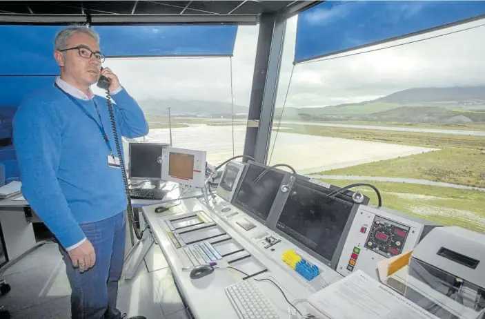  ??  ?? Carlos Font, en el interior de la torre de control de Pamplona, conversa con el piloto de un avión minutos antes de que tome tierra.