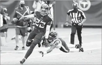  ?? WADE PAYNE/AP ?? Titans running back Derrick Henry avoids a tackle on a 53-yard gain on a screen pass in overtime Sunday.