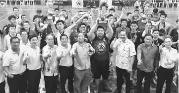  ??  ?? Nogeh (front, fifth left) poses with the organising committee and the teams at the end of the final match. On his right is SUPP Bau chairman Chong Bui Ling.