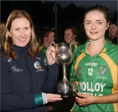  ??  ?? Catherine Kelly receives the cup from Melanie Ní Dhuinn,