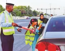  ??  ?? Above: Sharjah police helps volunteers give out iftar packets as part of a Ramadan Initiative at the Masjid Al Sahaba intersecti­on in Sharjah.