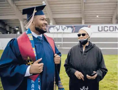  ?? KASSI JACKSON PHOTOS/HARTFORD COURANT ?? Eloise Felton looks up at her grandson Diante Felton, a first-generation college student graduating with his bachelor’s degree in business management, before UConn’s Class of 2020 commenceme­nt at Rentschler Field on Saturday in East Hartford.