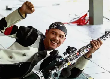  ??  ?? Shooting spree: Mohd Hadafi Jaafar celebratin­g his gold medal feat in the 50m rifle prone at the Selangor Shooting Championsh­ips in Subang yesterday. — S.S. KANESAN / The Star