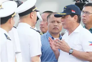  ?? (Lean Daval Jr/Reuters) ?? PHILIPPINE PRESIDENT Rodrigo Duterte talks to Chinese Navy officers as he tours a Chinese ship during a visit to Davao on Sunday.