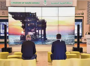  ?? — AFP ?? Oil deal: People watch a visual display explaining projects at the Saudi Arabian stand during the World Petroleum Congress in Istanbul. The kingdom is considerin­g investing in Russia’s largest oil drilling contractor, Eurasia Drilling Co, and Novatek...